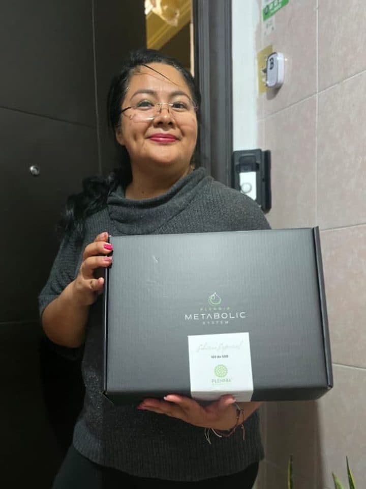Clienta recibiendo su kit Plennia Metabolic System en la puerta de su casa