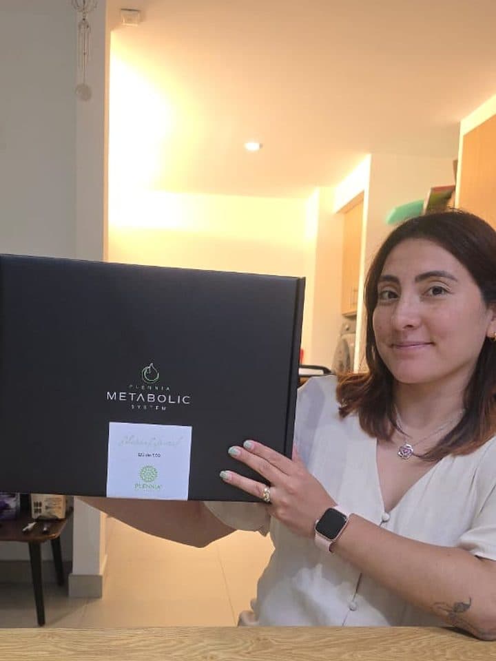 Clienta mostrando en casa la caja del Plennia Metabolic System